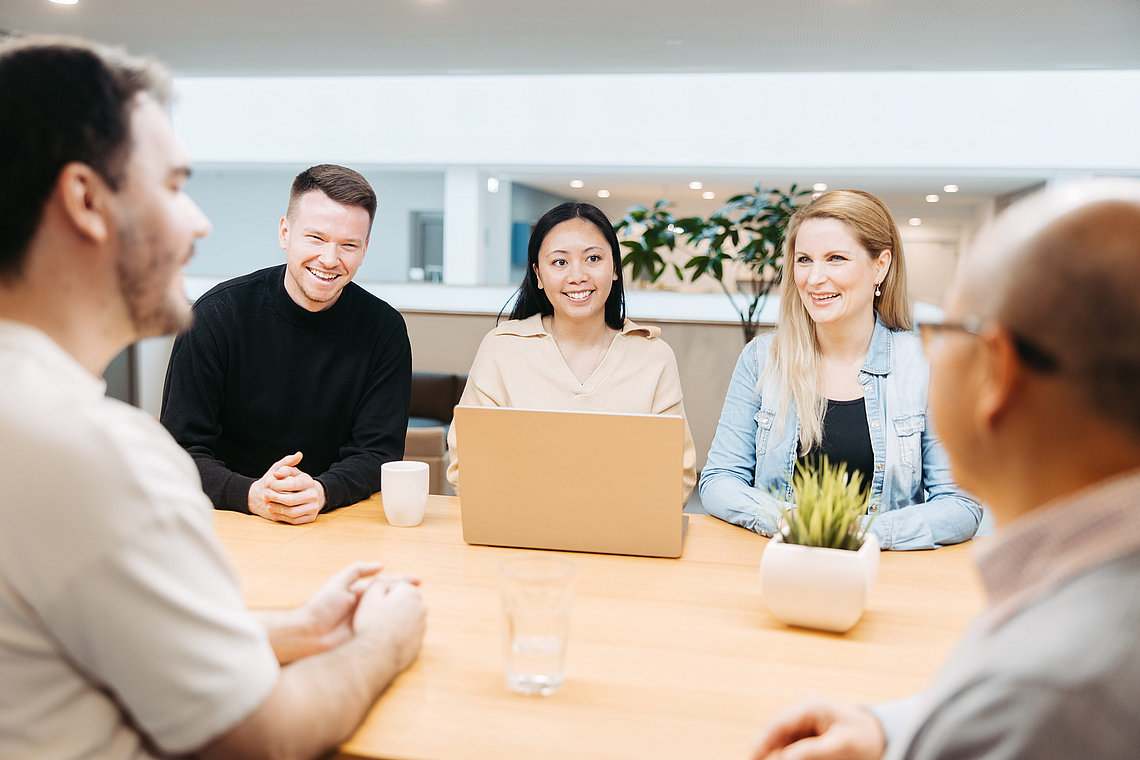 Kolleg:innen am Laptop in der Kaffeeküche